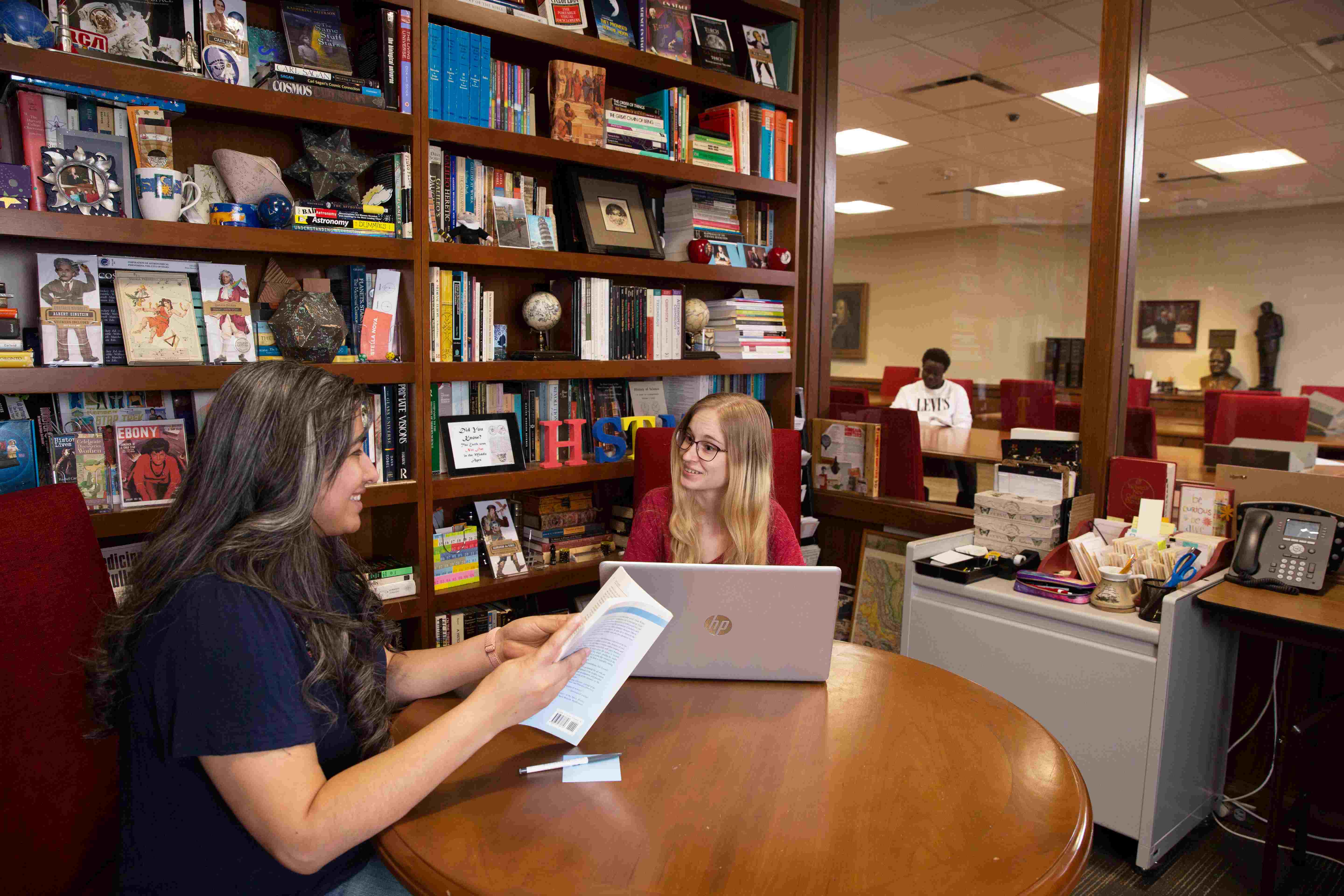 A consultation between two people in a room on the 5th floor of Bizzell
