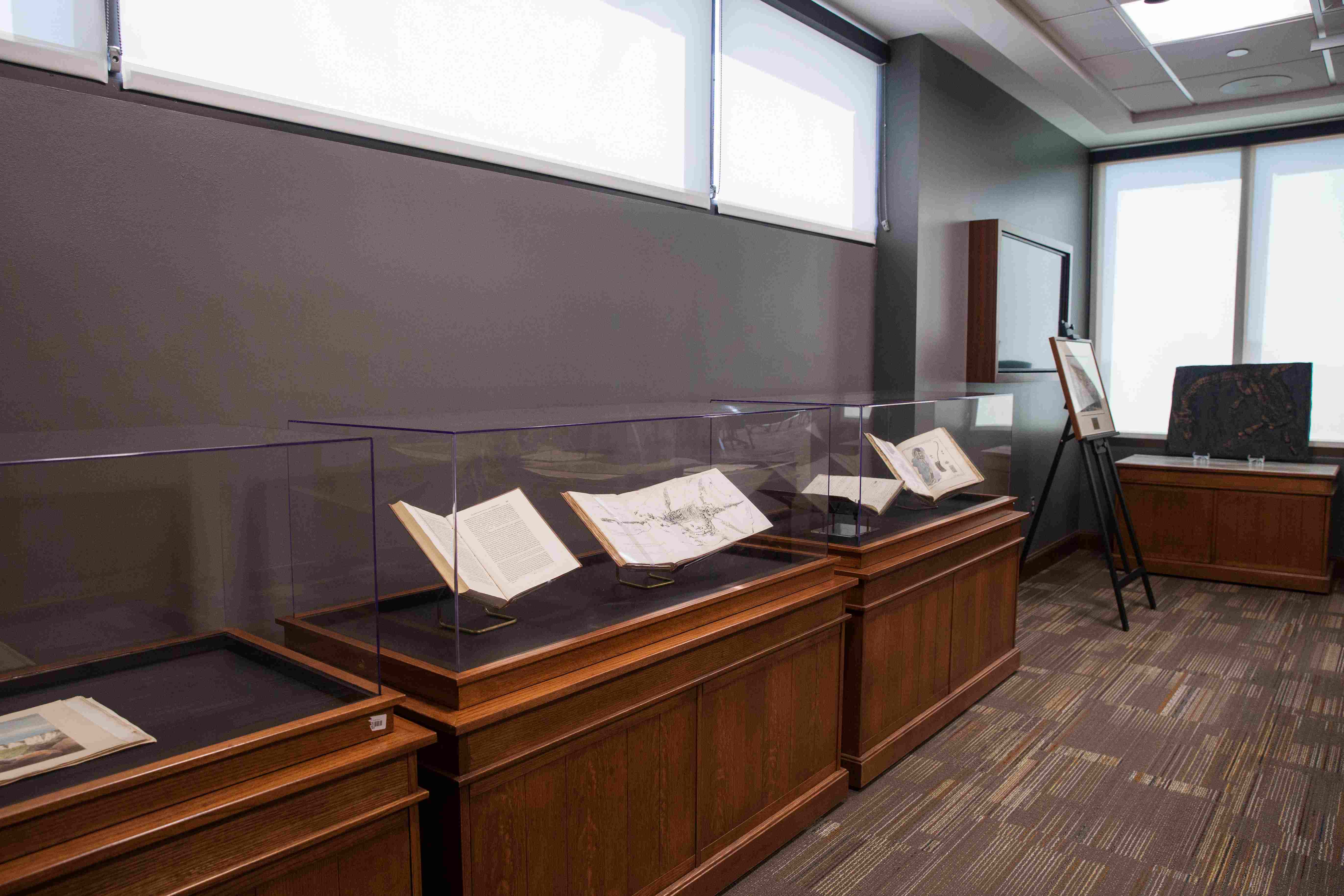 Display cases with open books in the Bizzell 5th floor exhibit space