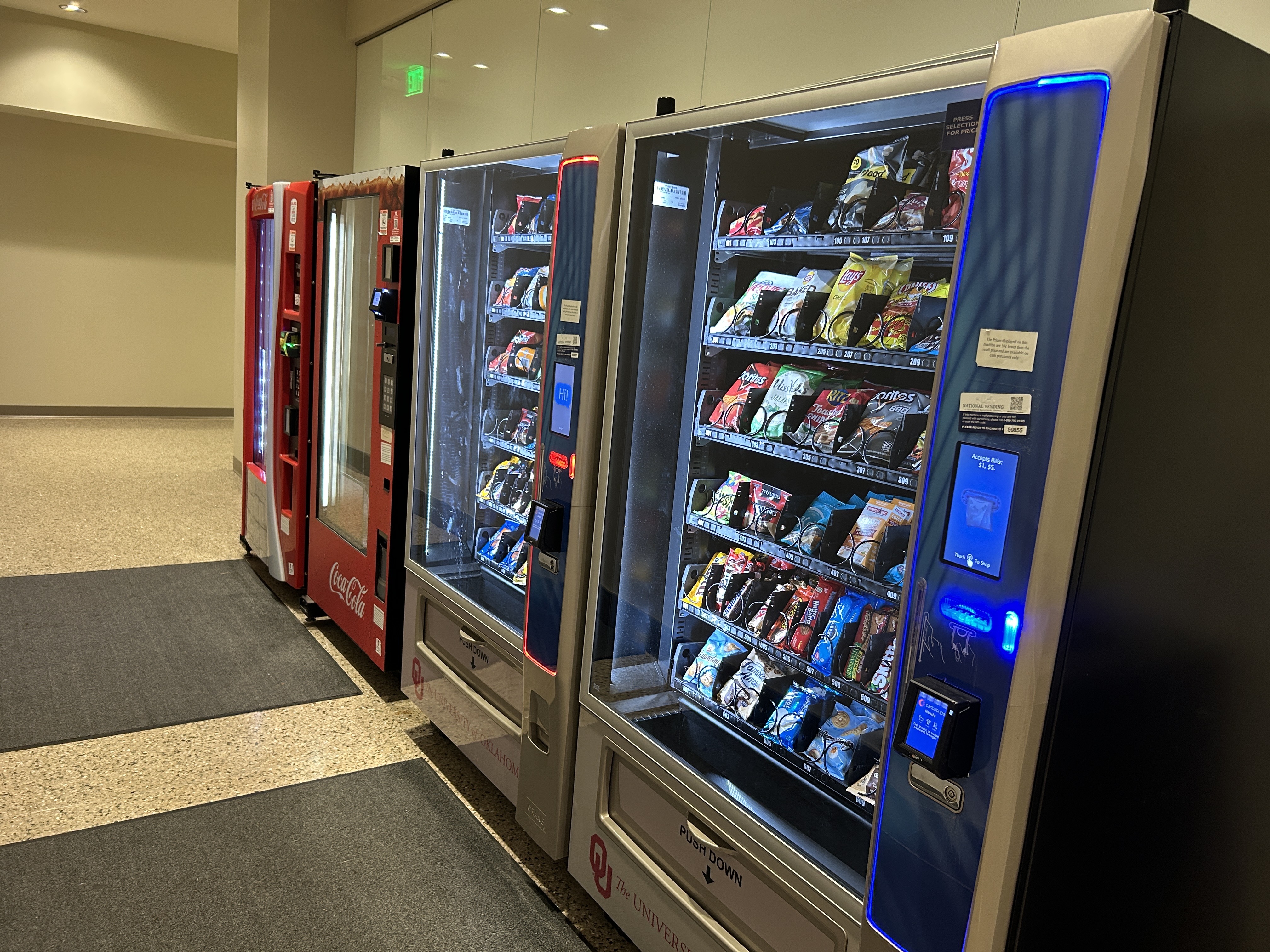 Two silver snack vending machines and two red drink vending machines