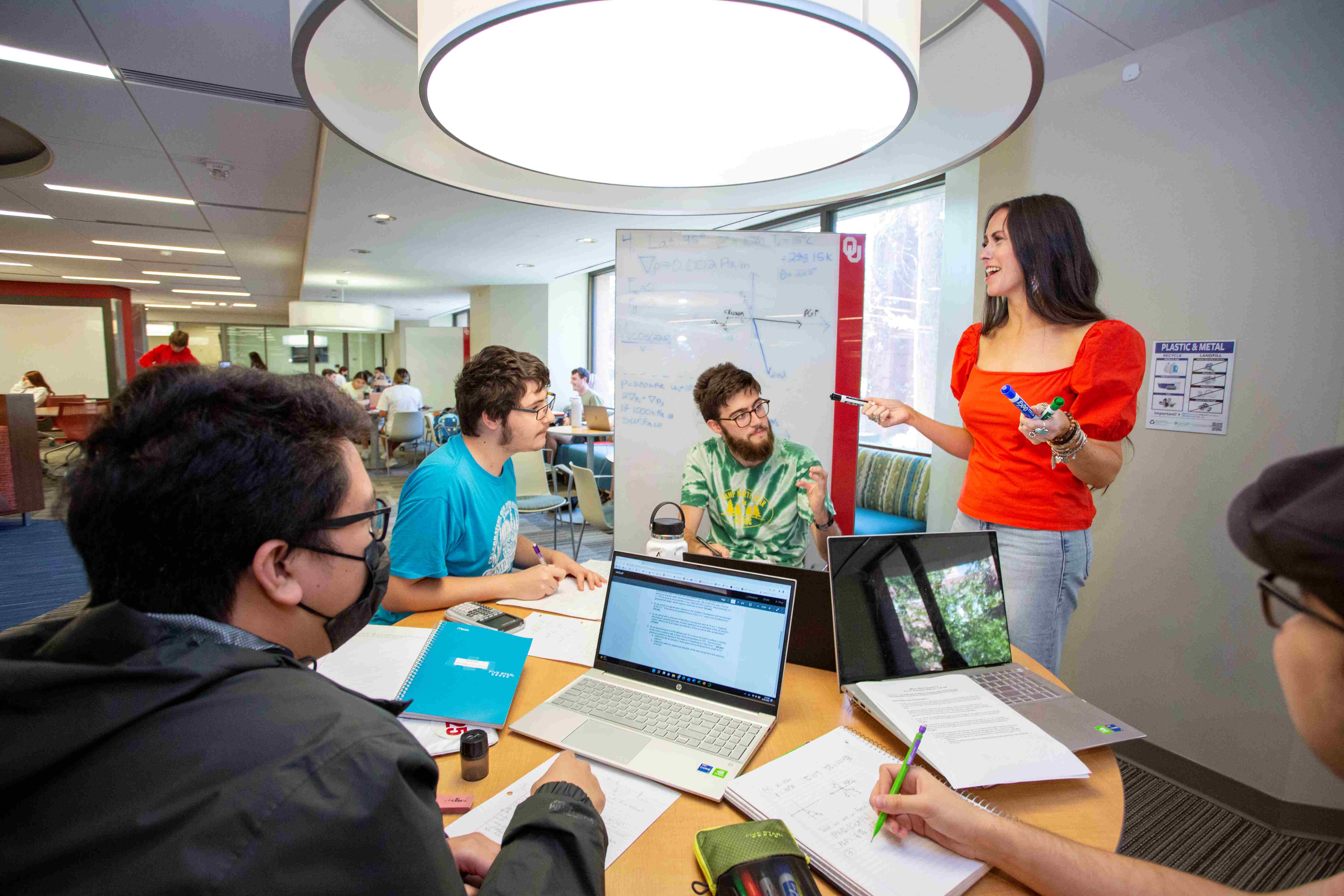 A Libraries staff member is giving a consultation to a group of students around a table 