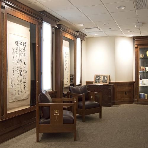 Two leather chairs in the Chinese Literature Translation Archive space are arranged in front of a window with posters on either sie